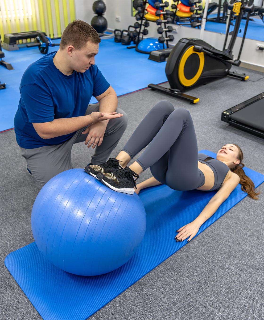 Physiotherapist guiding a leg exercise in the rehab gym